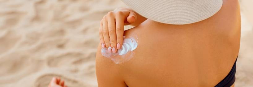 5 Beach Safety Tips From Life in Paradise Vacation Rentals: A woman putting on sunscreen 