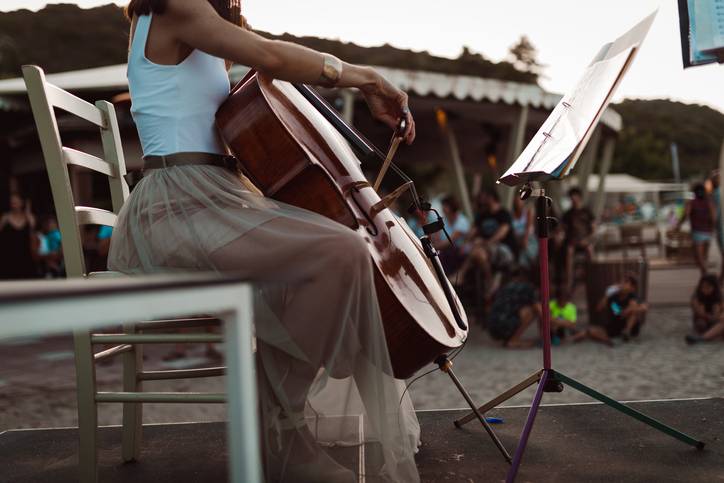 woman plays the bass at an outdoor beach concert